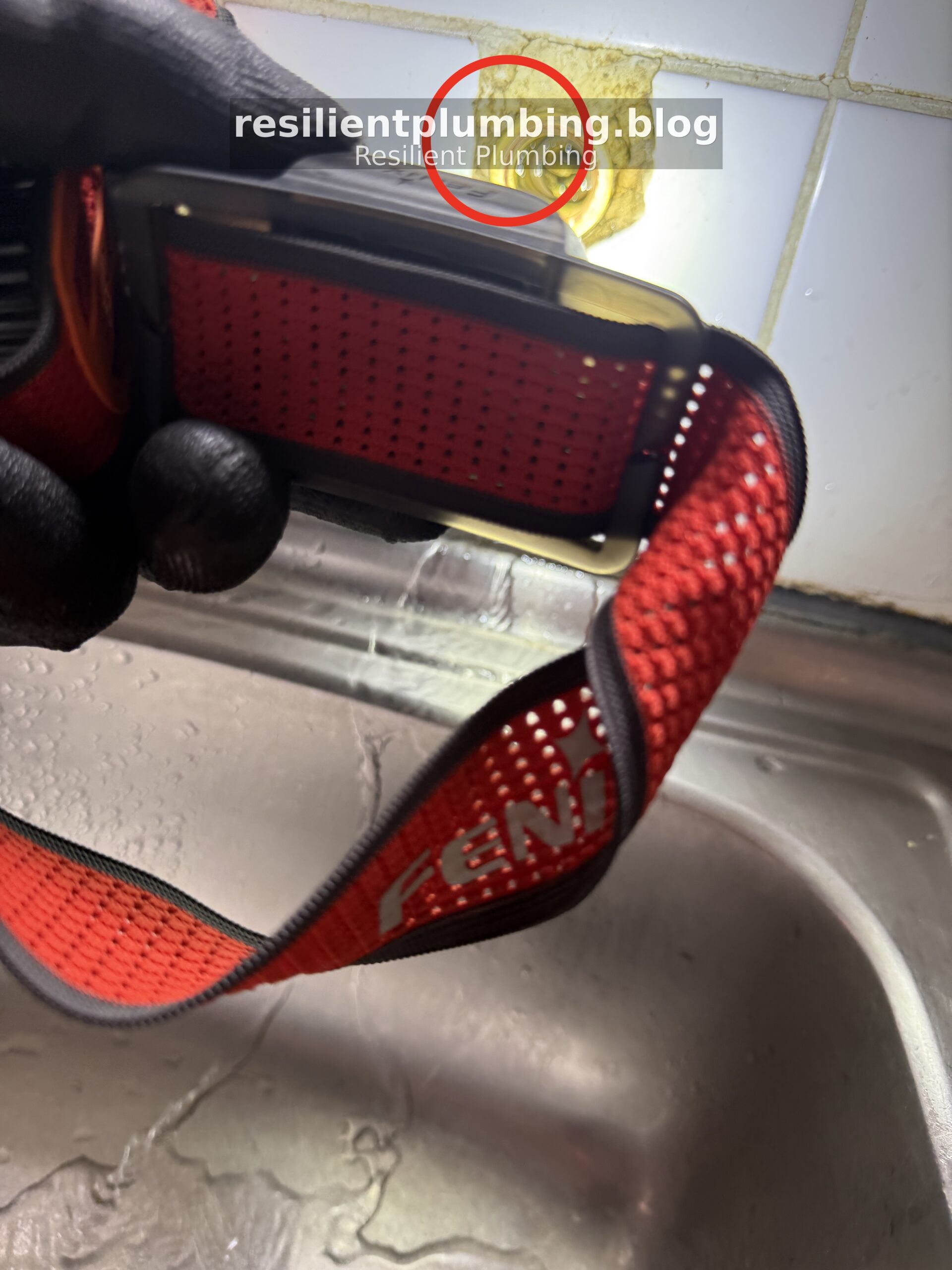 Fenix headlamp illuminating tap seater inside wall cavity showing water dripping