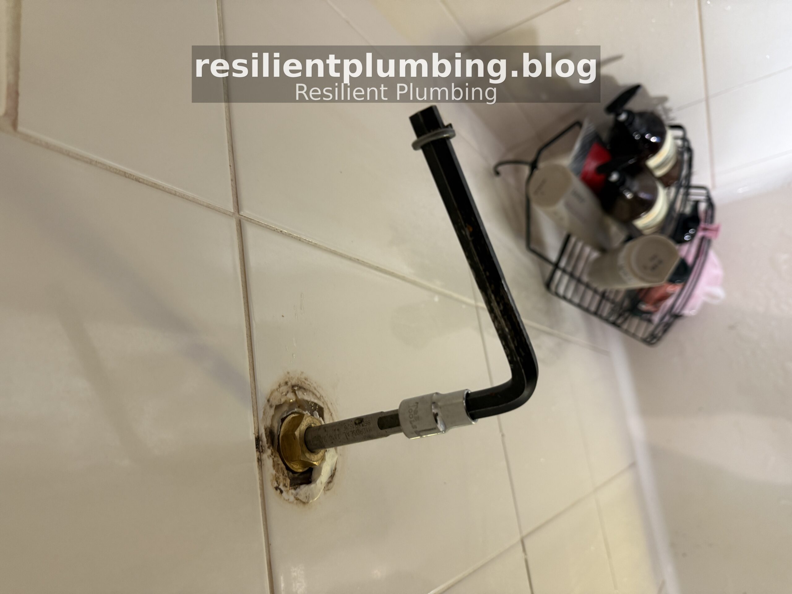 L-shaped tap seater resurfacing tool inserted into brass fitting in wall