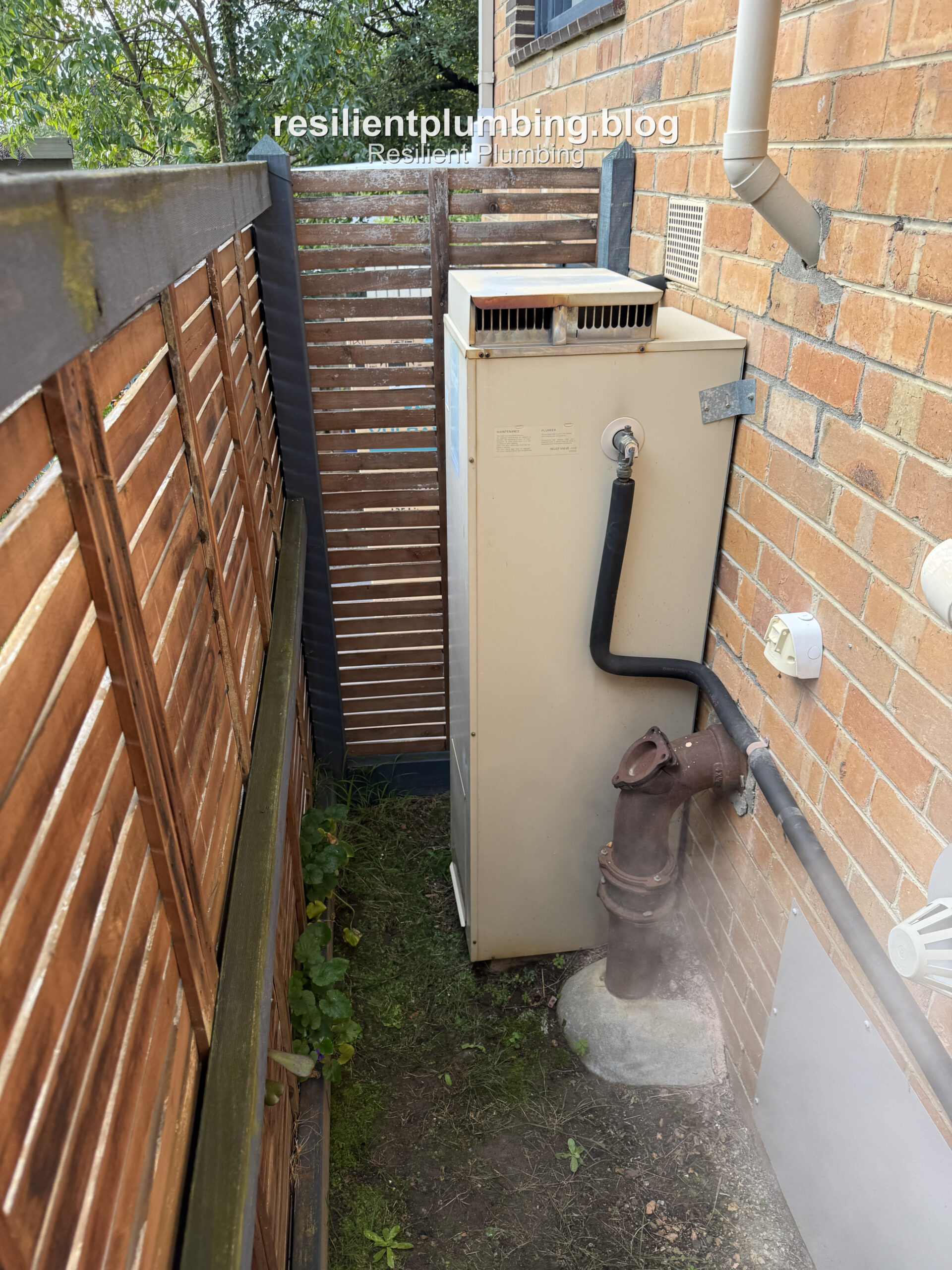 Old gas storage hot water unit installed beside a Vermont home